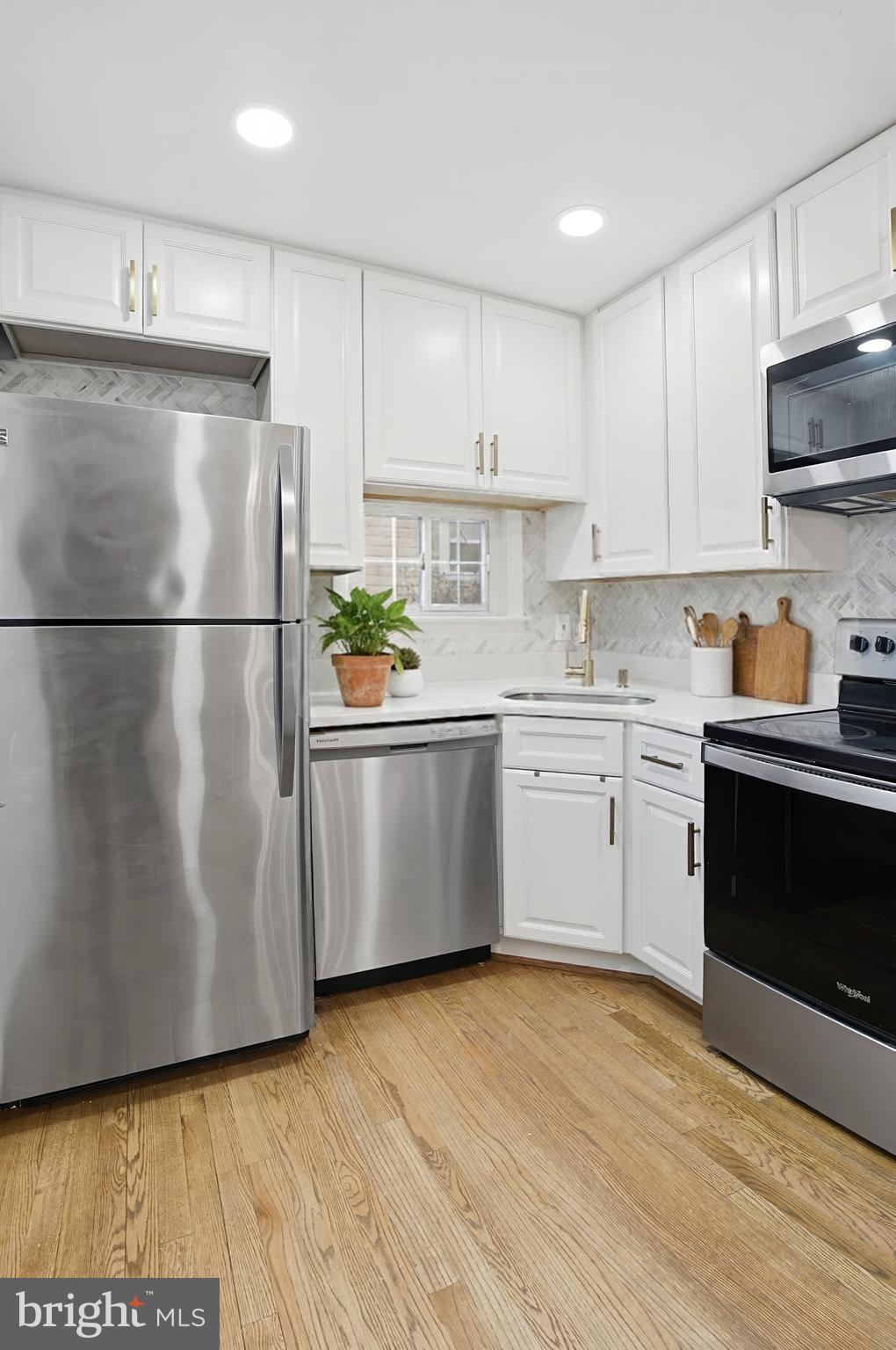3339 Acton Road Parkville, MD 21234 - Photo 10 of 37 a kitchen with a refrigerator a stove a microwave and cabinets