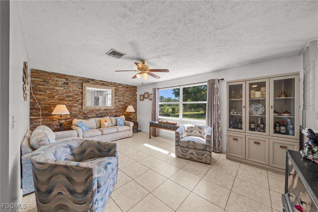 4121 16th Avenue Northeast Naples, FL 34120 - Photo 2 of 35 a living room with furniture and large windows