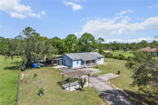 a view of a house with pool and sitting area