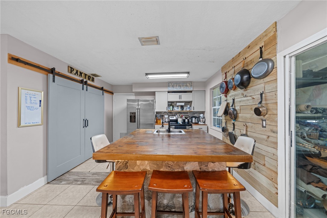 4121 16th Avenue Northeast Naples, FL 34120 - Photo 6 of 35 a dining room with a rug table and chairs