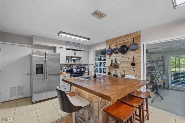 a kitchen with stainless steel appliances granite countertop a sink and a refrigerator