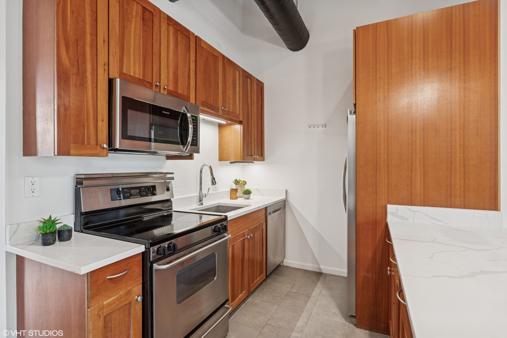 331 South Peoria Street, Unit PH6 Chicago, IL 60607 - Photo 11 of 46 a kitchen with stainless steel appliances a stove a microwave a sink and cabinets
