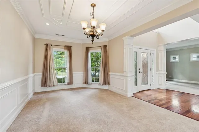 a view of a livingroom with a chandelier fan and windows