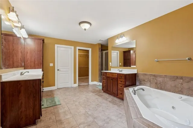 a bathroom with a tub sink shower and mirror
