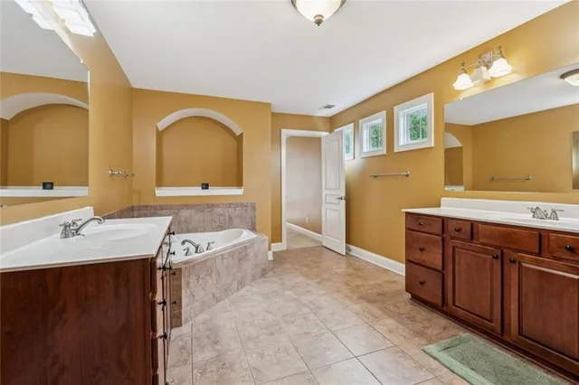 a spacious bathroom with a granite countertop tub sink and mirror