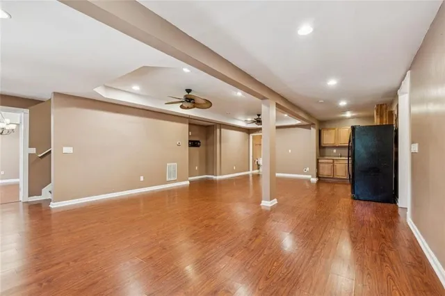 a view of an empty room with a window and wooden floor