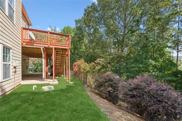 a view of a house with backyard and deck