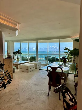 a view of a work space with furniture and floor to ceiling window