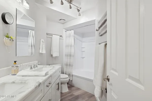 a bathroom with a granite countertop sink toilet and shower
