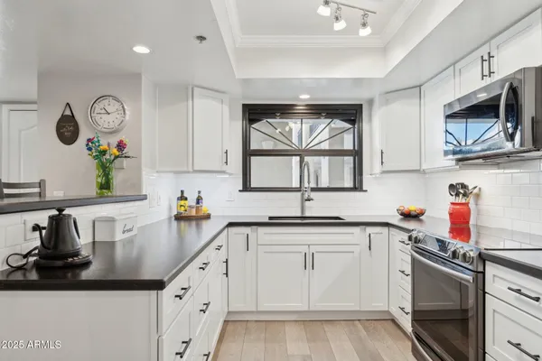a kitchen with stainless steel appliances granite countertop a sink and a stove top oven