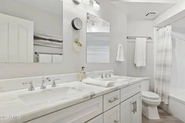 a bathroom with a granite countertop sink a toilet and a mirror