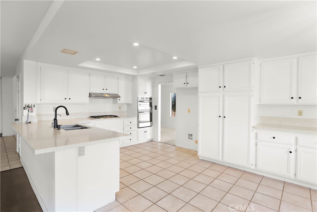 17316 Cold Spring Circle Riverside, CA 92503 - Photo 13 of 46 a kitchen with stainless steel appliances kitchen island sink refrigerator and cabinets
