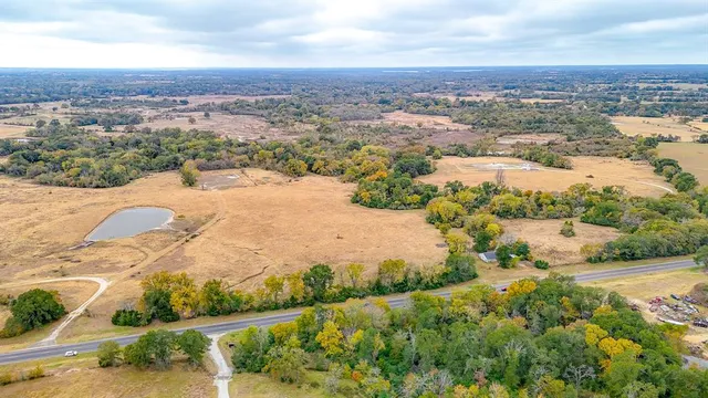an aerial view of ocean and residential houses with outdoor space