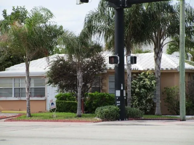 a view of a house with a yard and large trees