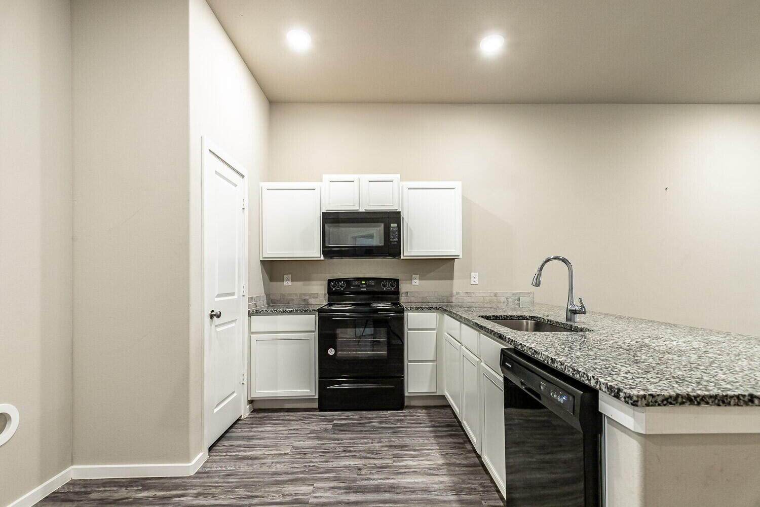 1901 Langford Avenue, Unit B Lubbock, TX 79407 - Photo 3 of 11 a kitchen with stainless steel appliances granite countertop a stove top oven a sink and dishwasher
