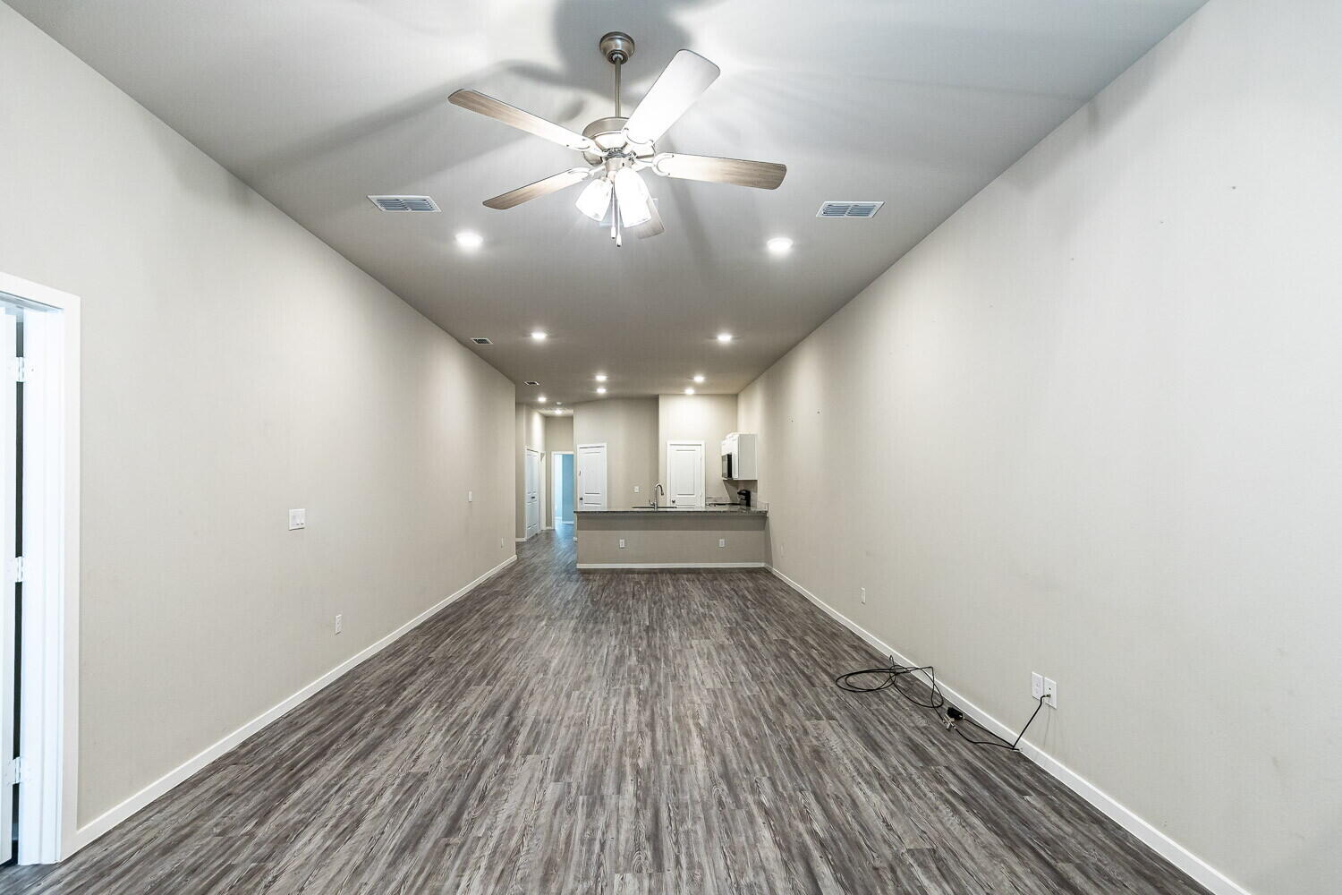 1901 Langford Avenue, Unit B Lubbock, TX 79407 - Photo 4 of 11 an empty room with wooden floor and windows