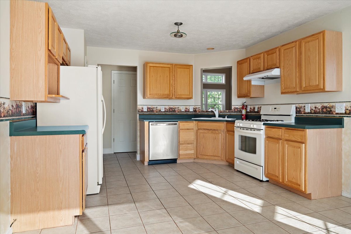 606 Windward Way Heyworth, IL 61745 - Photo 7 of 30 a kitchen with white cabinets and white appliances