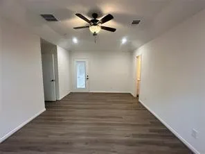 a view of an empty room with wooden floor