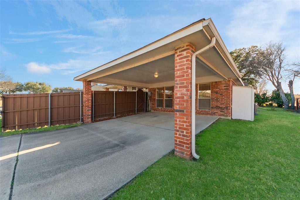 3308 North Spring Drive Richardson, TX 75082 - Photo 30 of 38 Features a convenient attached rear carport, providing covered parking and added flexibility. Perfect for extra vehicles, boat storage, or shaded outdoor use, this covered space offers both protection and practicality. The extended driveway allows for additional parking, making it ideal for guests and gatherings.