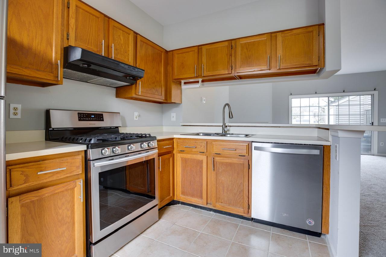 3005 McMaster Court Herndon, VA 20171 - Photo 6 of 26 a kitchen with stainless steel appliances granite countertop a stove a sink and a microwave