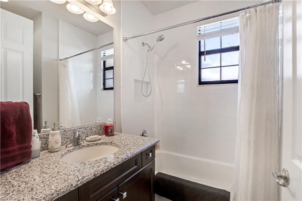 4310 Aurora Street Naples, FL 34119 - Photo 12 of 17 a bathroom with a granite countertop sink and a mirror
