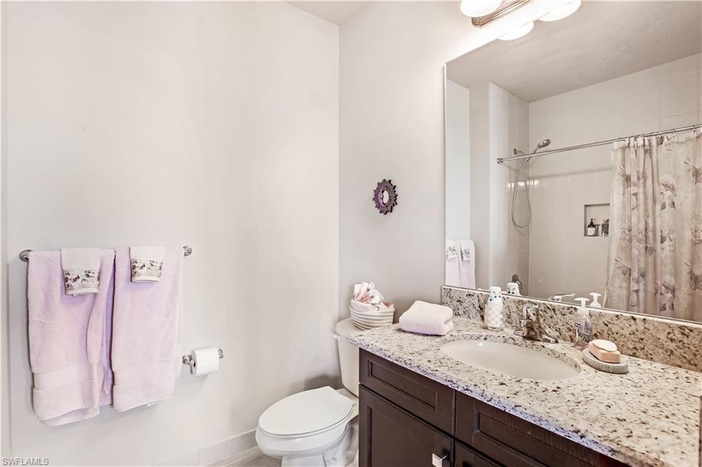 4310 Aurora Street Naples, FL 34119 - Photo 14 of 17 a bathroom with a granite countertop sink a toilet and shower