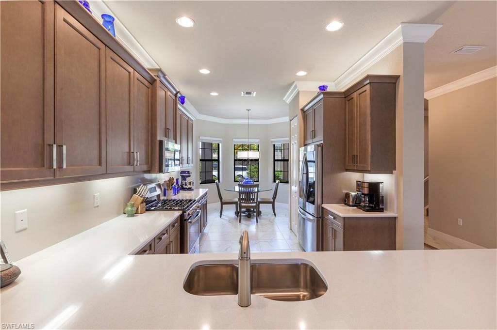 4310 Aurora Street Naples, FL 34119 - Photo 3 of 17 a kitchen with stainless steel appliances kitchen island granite countertop a sink and cabinets