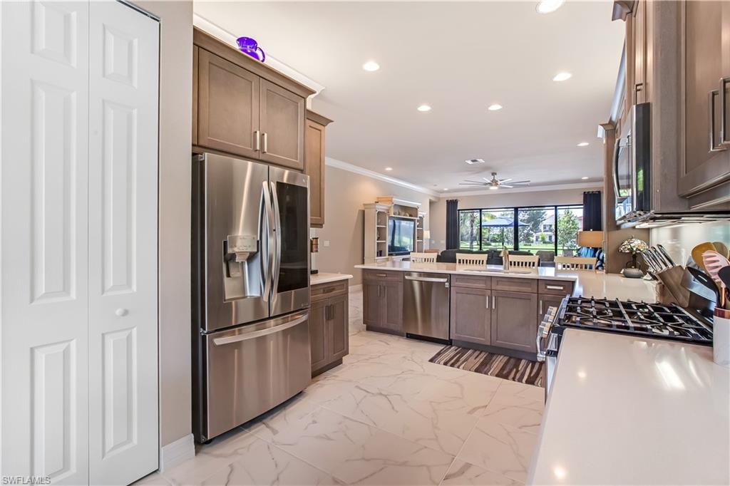 4310 Aurora Street Naples, FL 34119 - Photo 4 of 17 a kitchen with stainless steel appliances a refrigerator and a stove top oven