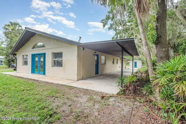 a view of a house with a yard and potted plants