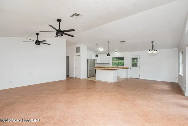 a view of a kitchen with a sink and refrigerator