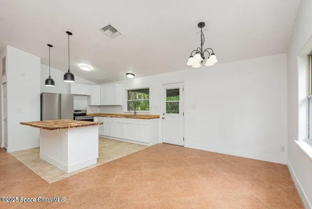 a view of a kitchen with stainless steel appliances granite countertop a sink a stove and a window