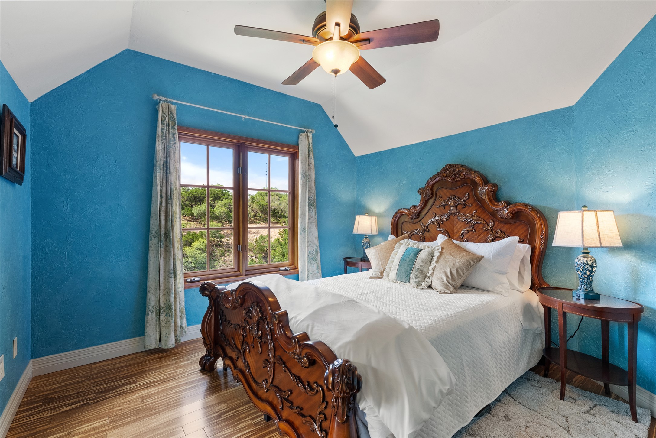 1354 The High Road Austin, TX 78746 - Photo 29 of 40 Ornate bed frame in a sun-drenched bedroom with rich wooden flooring.