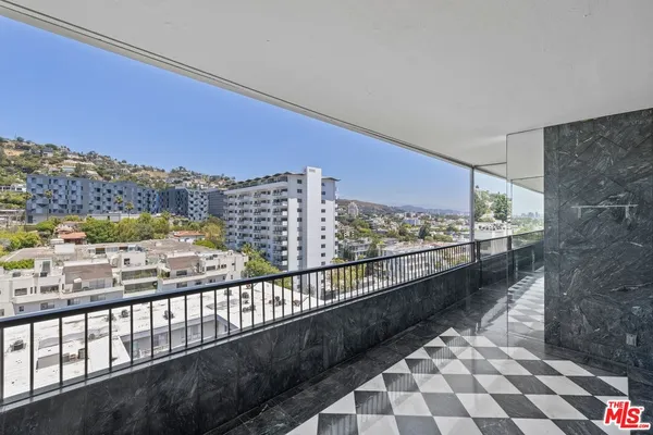 a balcony with wooden floor and city view