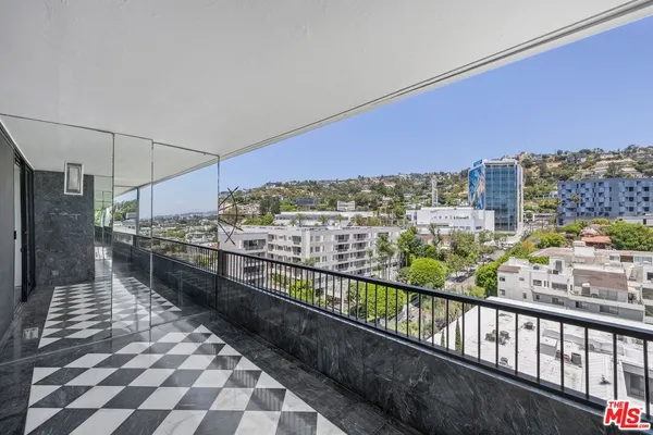 a view of a balcony with couches and wooden floor
