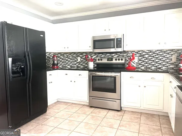 a kitchen with stainless steel appliances kitchen island granite countertop a refrigerator and a stove top oven
