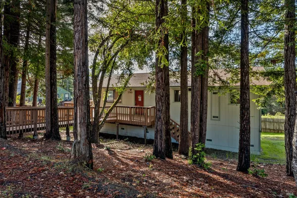 a view of a house with backyard and trees