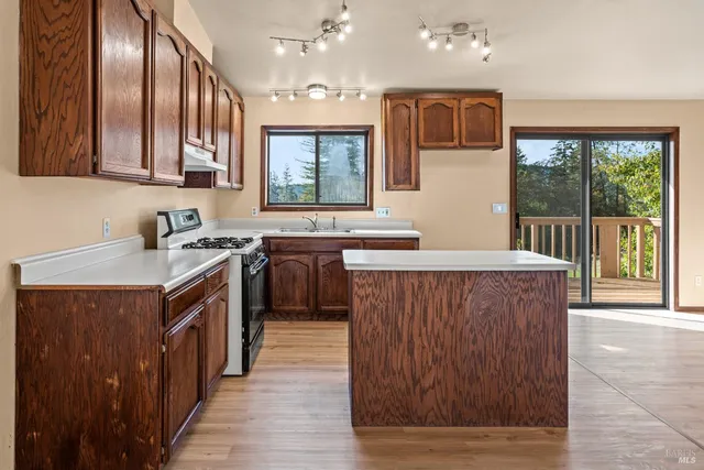 a kitchen with stainless steel appliances granite countertop a sink stove and cabinets