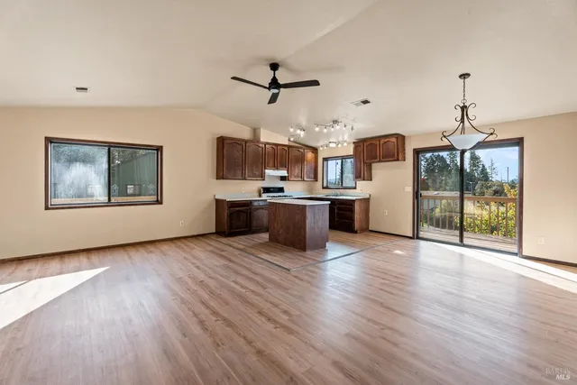 a view of a kitchen with a sink stove cabinets and empty room