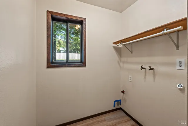 a view of a small space with wooden floor and a window