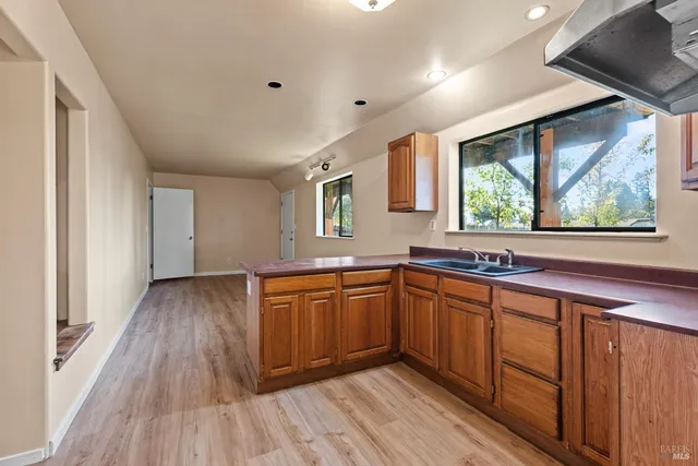 a kitchen with stainless steel appliances granite countertop wooden floors and sink