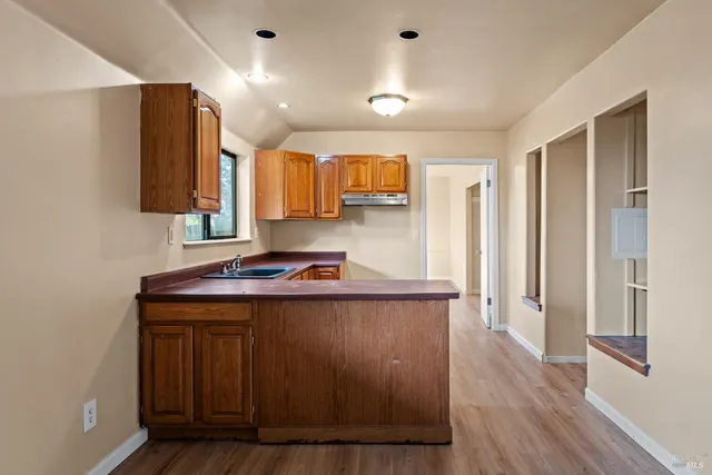 a kitchen with stainless steel appliances granite countertop a sink and a refrigerator