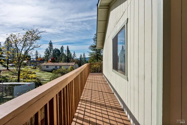 a view of a balcony with wooden floor and fence