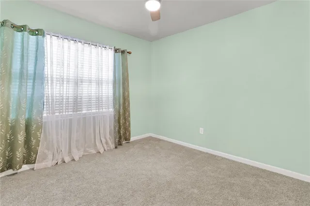 an empty room with cabinet and windows