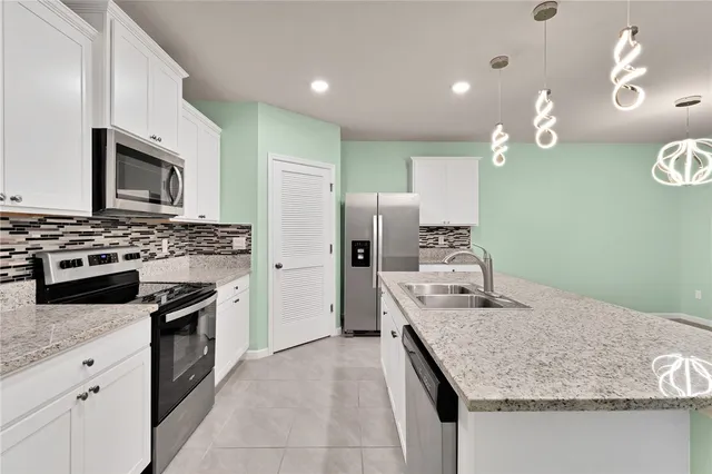 a kitchen with kitchen island granite countertop stainless steel appliances and stove top oven