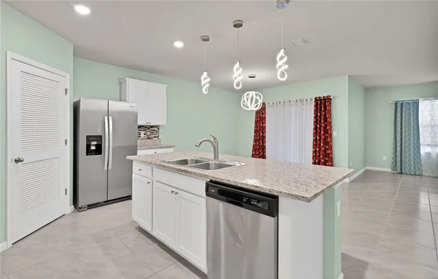 a kitchen with stainless steel appliances granite countertop a sink and a refrigerator