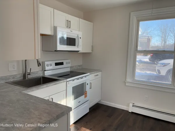 a kitchen with granite countertop a stove and a microwave