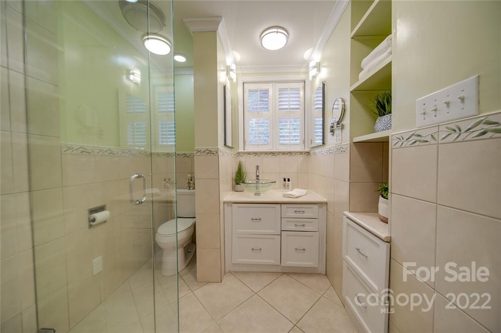 811 Queens Road, Unit 2 Charlotte, NC 28207 - Photo 17 of 31 a bathroom with a granite countertop sink a toilet and a mirror