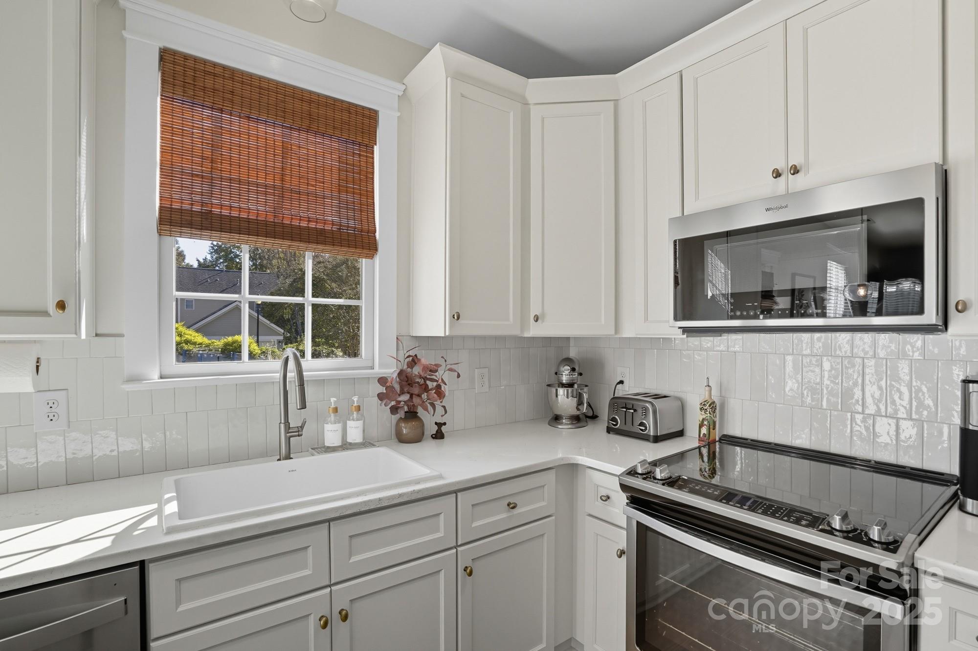 911 Cara Court Fort Mill, SC 29708 - Photo 19 of 48 a kitchen with white cabinets and window