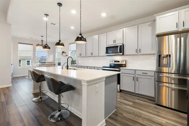 a kitchen with kitchen island a sink a counter and chairs