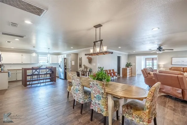 a dining room with furniture a chandelier and wooden floor